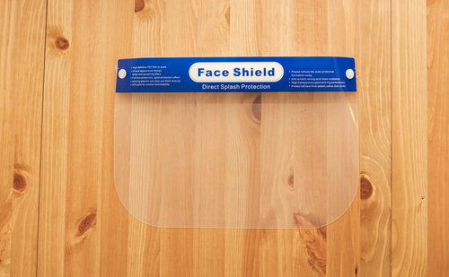 木製の板に置かれた青いフレームのフェイスシールド