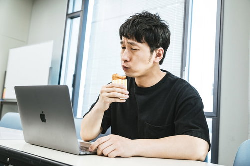 自分の動画を見ながらファミリーチキンを食べるユーチューバー男性