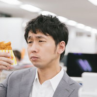 ファミリーチキンの前で困るスーツ姿の男性の写真