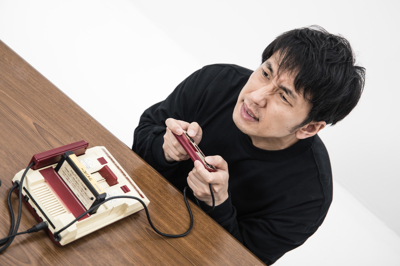 ゲームオーバーで落胆した表情を見せる黒いシャツの男性［モデル：大川竜弥］
