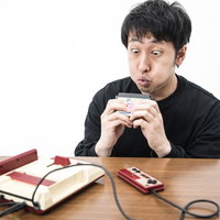 カセットに息を吹きかけるゲーマーの写真