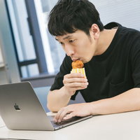 フライドチキンで唇を潤す乾燥が気になる男性の写真