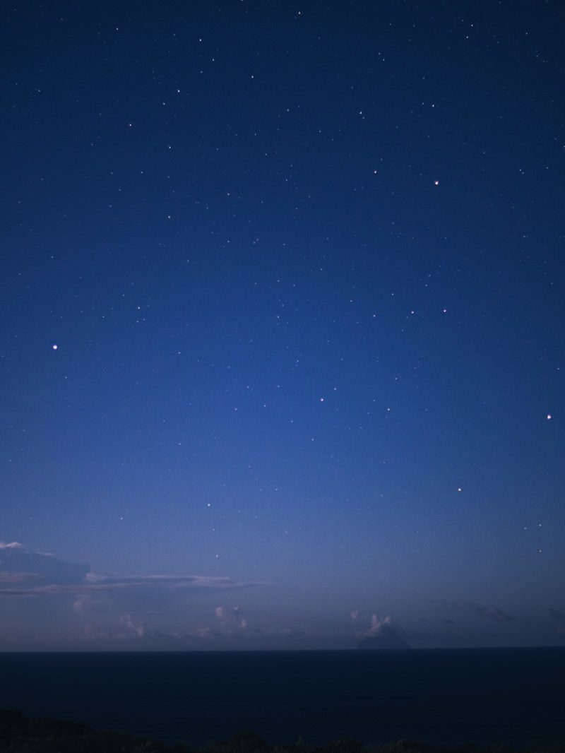 月明かりに照らされた夜の南硫黄島と星空の風景