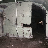 亀裂が入り今にも崩れそうな船見台トーチカ内部の壁の写真