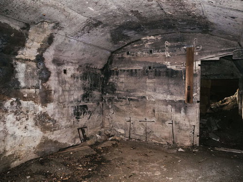 壁が剥がれ中の鉄筋が覗いた部分もあるが比較的形を留めている船見台トーチカの内部