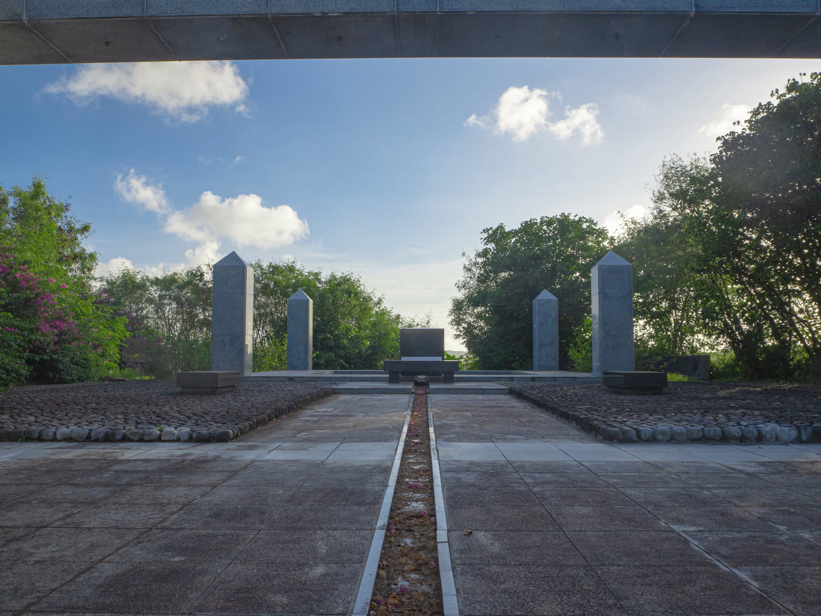 青空の下に建つ硫黄島の鎮魂の丘の慰霊碑と周囲の緑の木々