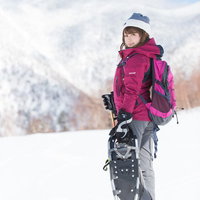 平湯温泉スキー場の雪山でスノーシューを履く女性の写真