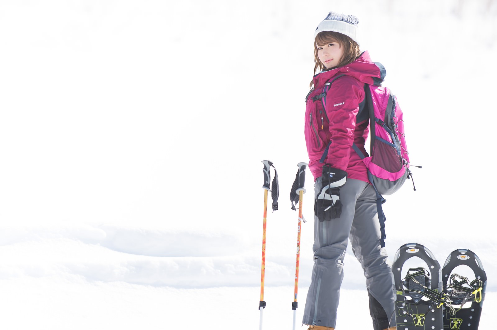 雪山でスノーシューとストックを持つ女性［モデル：茜さや］