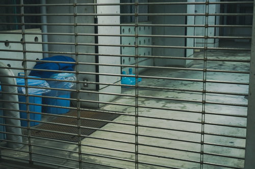 金属製シャッターで閉じられたゴミ置き場の廃棄物管理