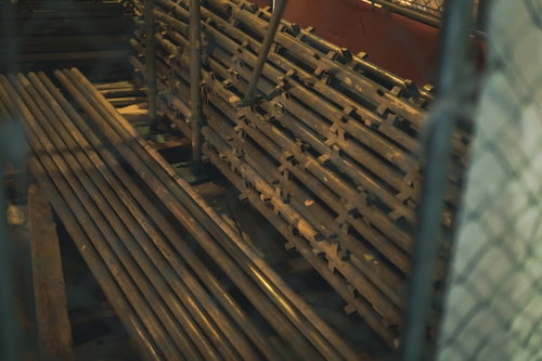 工事現場の資材置き場に積み重ねられた単管パイプ