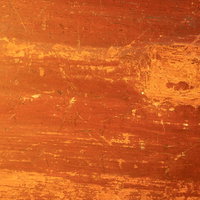 細かい傷と剥げがついたオレンジから茶色の天板の写真