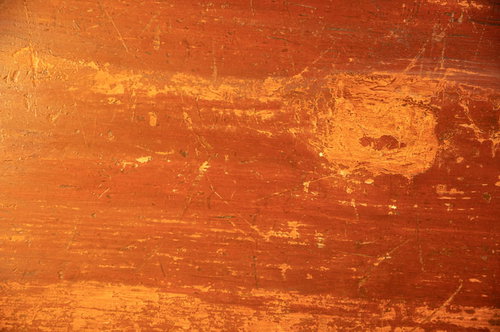 細かい傷と剥げがついたオレンジから茶色の天板