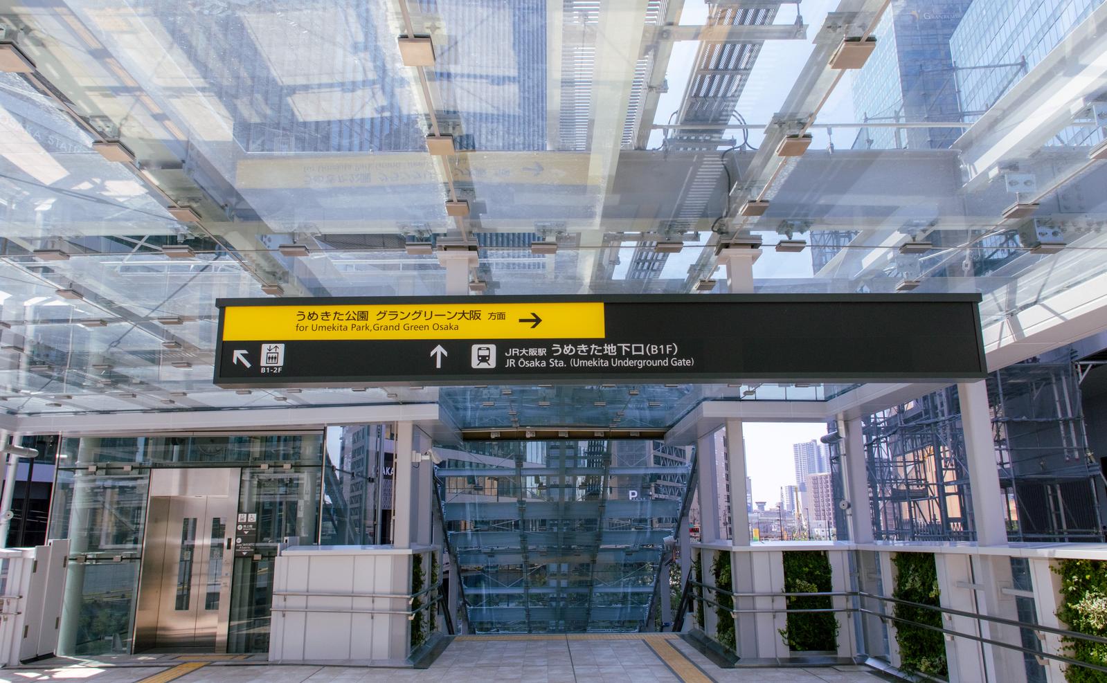 梅田駅前のグラングリーン大阪再開発エリアに立つ黄黒の案内看板