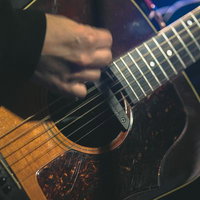 クラシックギターを弾く男性ミュージシャンの写真