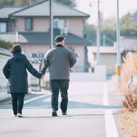 仲良く手を繋いで散歩する夫婦の午後、住宅地での日常の風景の写真