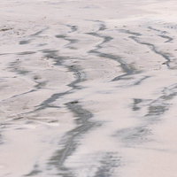 北泉海岸の引き潮で現れた砂浜の波状模様と潮流の痕跡の写真