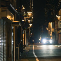夜間の広野町商店街を走行するハイビームの車の写真