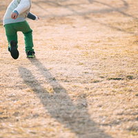 砂利の公園を元気に走る子ども 天神岬スポーツ公園の写真
