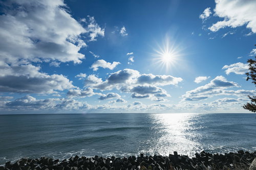 広野町の浜街道から見る太陽が照る海岸線と水平線の風景