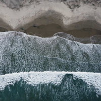 北泉海岸の波打ち際に砂浜を洗う白波と海岸風景の写真