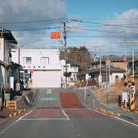 広野町駅の踏切を渡る線路と黄黒い警告灯の風景の写真