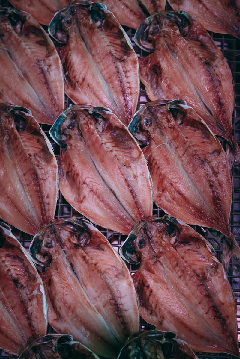 小名浜港の市場で干されているアジの開きが複数ネットに並んでいる