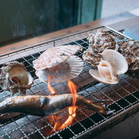 小名浜港での海鮮バーベキュー、貝類を炭火焼きで加熱調理する風景の写真