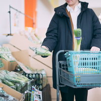 小高ストアで福島産の小松菜をショッピングカートに入れる買い物客の写真