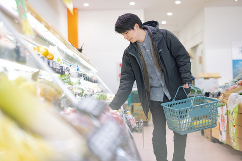 小高ストアで野菜を選ぶ男性の買い物風景