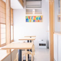 haccobaの和テイストな店内、木製テーブルと畳の間仕切りのある空間の写真