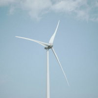 南相馬の海岸線に立つ風力発電の風車と曇り空の写真