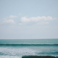 福島県の海岸線に打ち寄せる波と白い空の写真