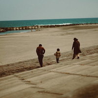 北泉海岸の砂浜を歩く親子連れの写真