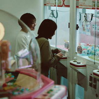 天神岬温泉しおかぜ荘のゲームセンターでUFOキャッチャーを楽しむ女性たちの写真