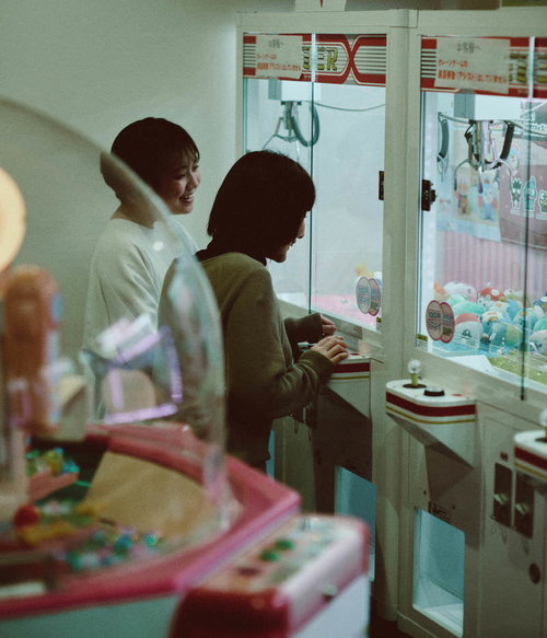 天神岬温泉しおかぜ荘のゲームセンターでUFOキャッチャーを楽しむ女性たち