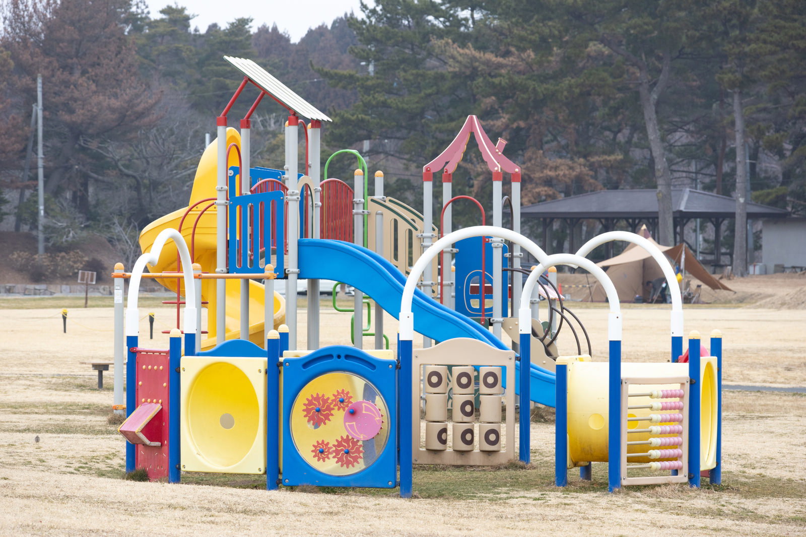 楢葉町天神岬スポーツ公園のカラフルな複合遊具。黄色と青の滑り台、赤や緑の手すりがある大型遊具