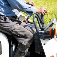 秋の稲田でコンバインを操作する農家の収穫風景の写真