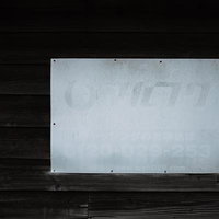 薄くなって文字が読み取りにくくなったマルフクの看板の写真