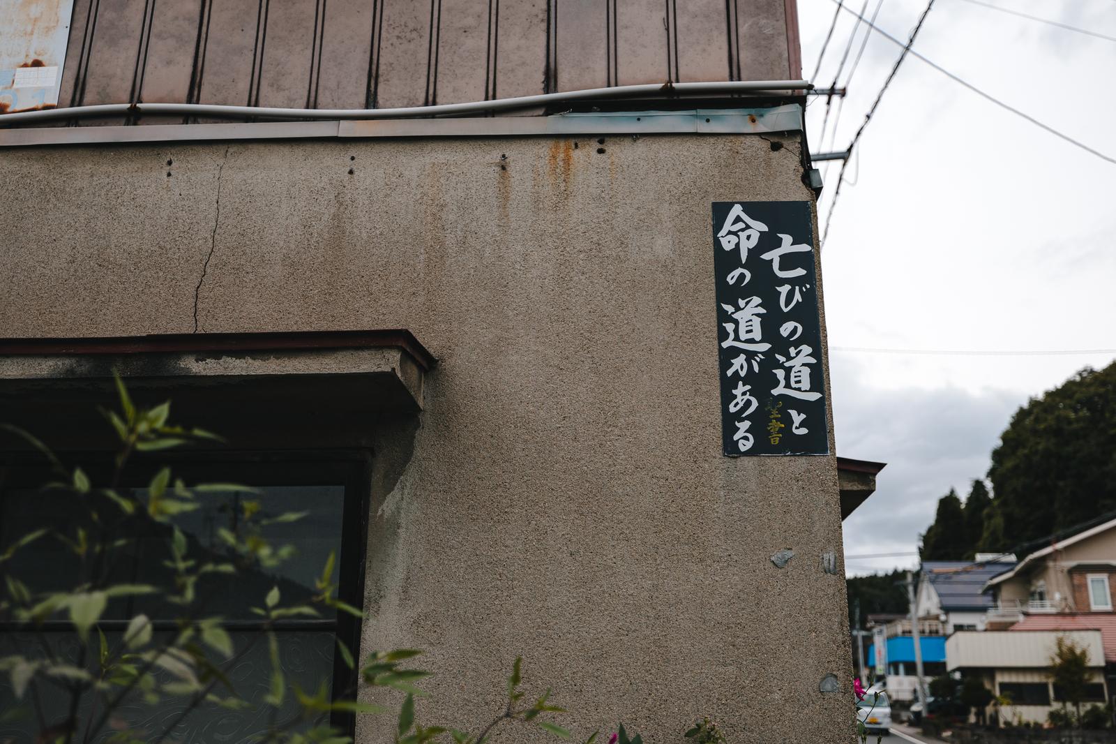 聖書の言葉「亡びの道と命の道がある」が白い文字で書かれた黒い看板