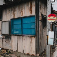 福島交通三芦バス停の古い待合室と駅舎の写真
