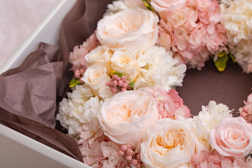 ギフトで届いたフラワーリースの飾り、淡いピンクとクリーム色のバラ