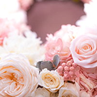 ピンクと白のプリザーブドフラワーで作られた贈り物のリースの写真