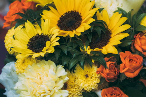 黄色いひまわりとオレンジ色のバラの夏の花束