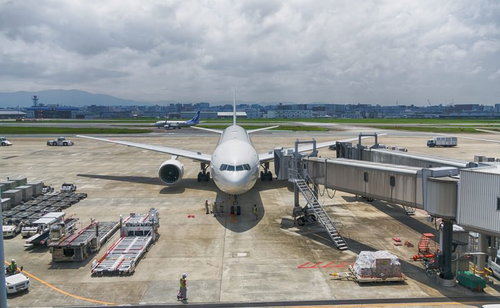 福岡空港に駐機した旅客機とジェット機、搭乗橋に接続された大型航空機
