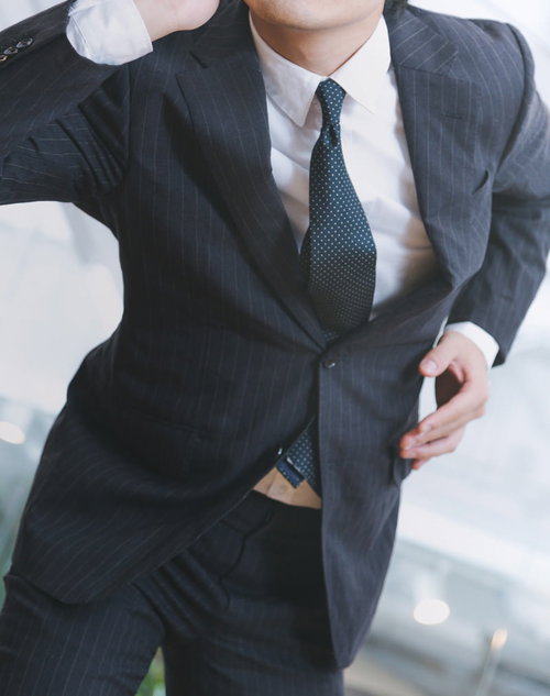 申告漏れを指摘され、スマホで急ぐ経理部長