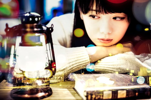 ランタンを見つめる文学美女、洋書に囲まれて（フォトモンタージュ）