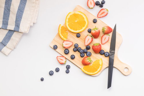 まな板に並ぶカット中のフルーツと包丁