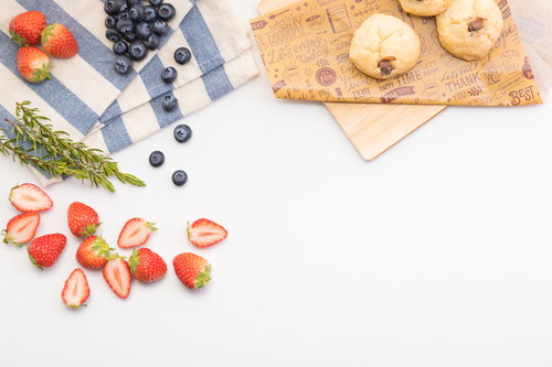 白い背景に並べたイチゴとブルーベリーのフルーツとクッキー