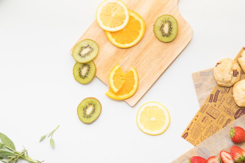 まな板に並ぶスライスされたキウイとオレンジ