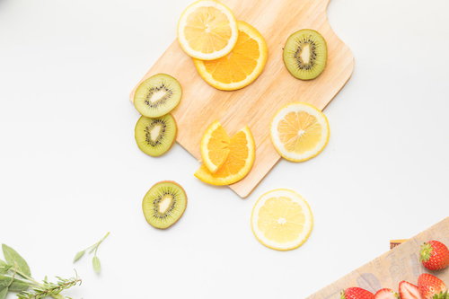 カッティングボードに放置されたままのカットフルーツ（オレンジ・レモン・キウイ）